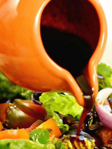Simple Balsamic Vinaigrette being poured over green salad.