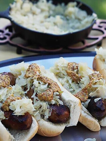 Beer Brats topped with sauerkraut and mustard.