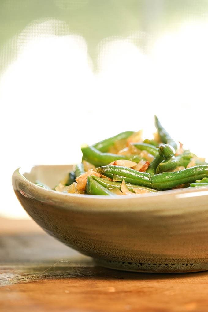 Green beans with bacon and onions in brown bowl