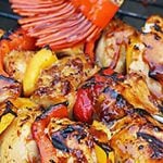 Chicken of bbq being basted with sauce. With Pinterest overlay.