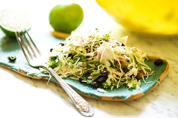 Mexican coleslaw recipe on blue plate with fork.