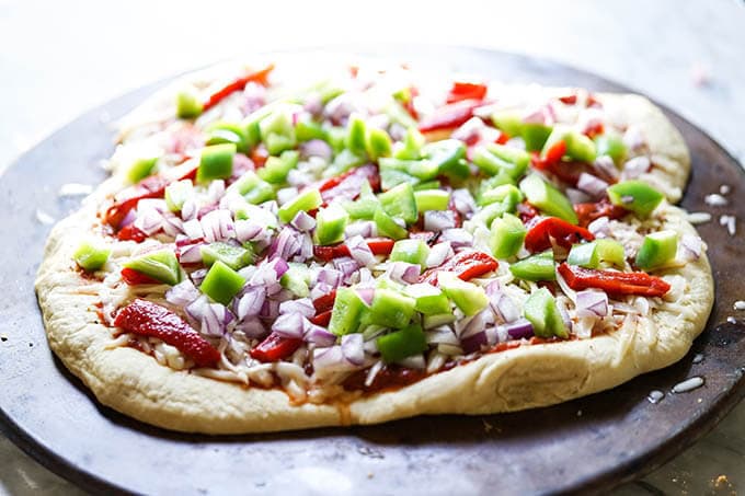 Pizza dough on baking stone ready to. go. in the oven.