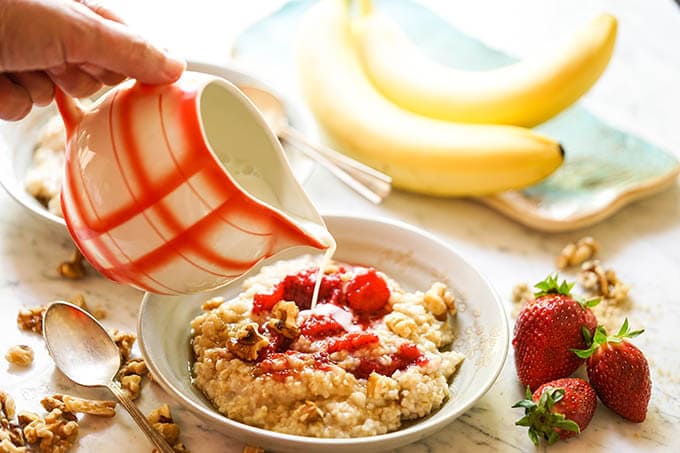 Oatmeal in bowl with strawberries topped off with milk