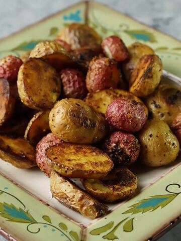 Roasted radishes and potatoes on plate.
