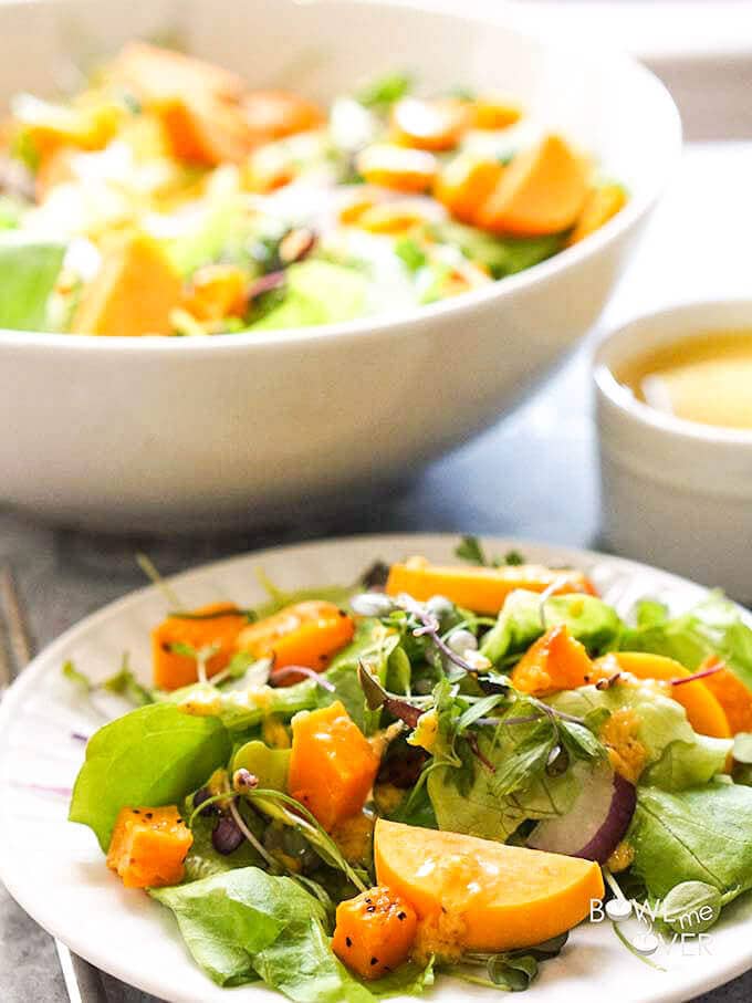 Fall Harvest Salad on white plate with salad dressing on the side