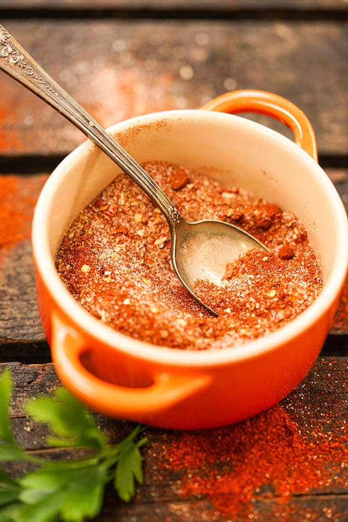 Fajita Spice Mix in orange bowl with spoon.