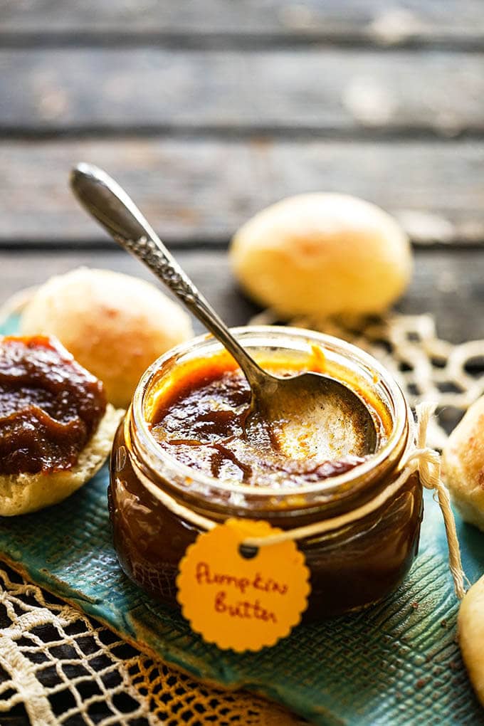 Pumpkin Butter Recipe in jar with spoon and rolls.