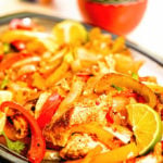 Oven baked fajitas on platter with lime