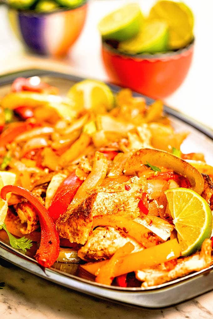 Oven baked fajitas on platter with lime