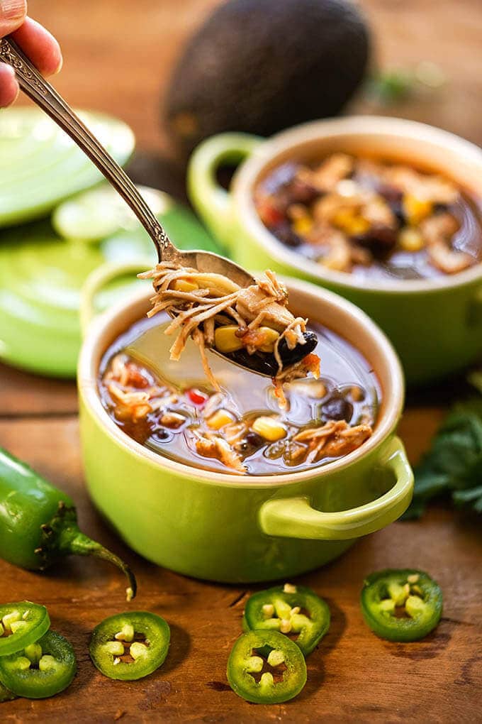 Chipotle Chicken Soup in green bowls with spoon.