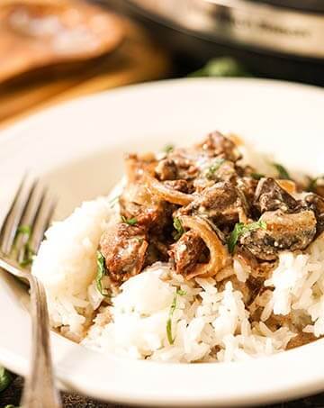 Easy Crock Pot Beef Stroganoff in white bowl with fork.