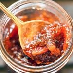 Fig Jam in jar with spoon filled with jam.