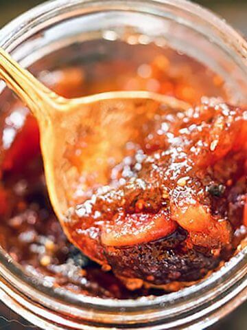 Fig Jam in jar with spoon filled with jam.