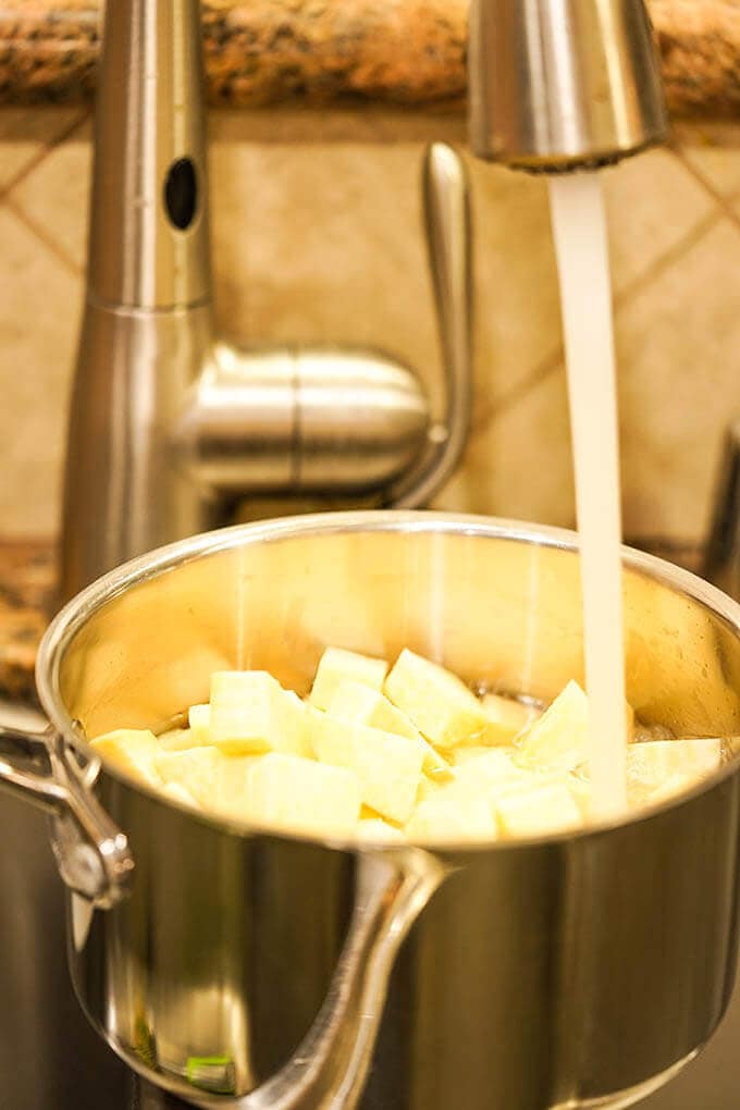 Pot with vegetables being filled with water. 