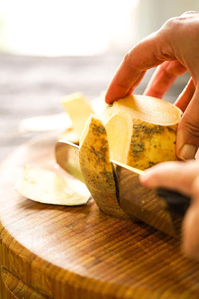 Slicing skin off rutabaga.