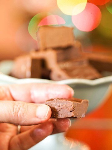 Fudge in green bowl with hand holding a piece - so chocolatey!