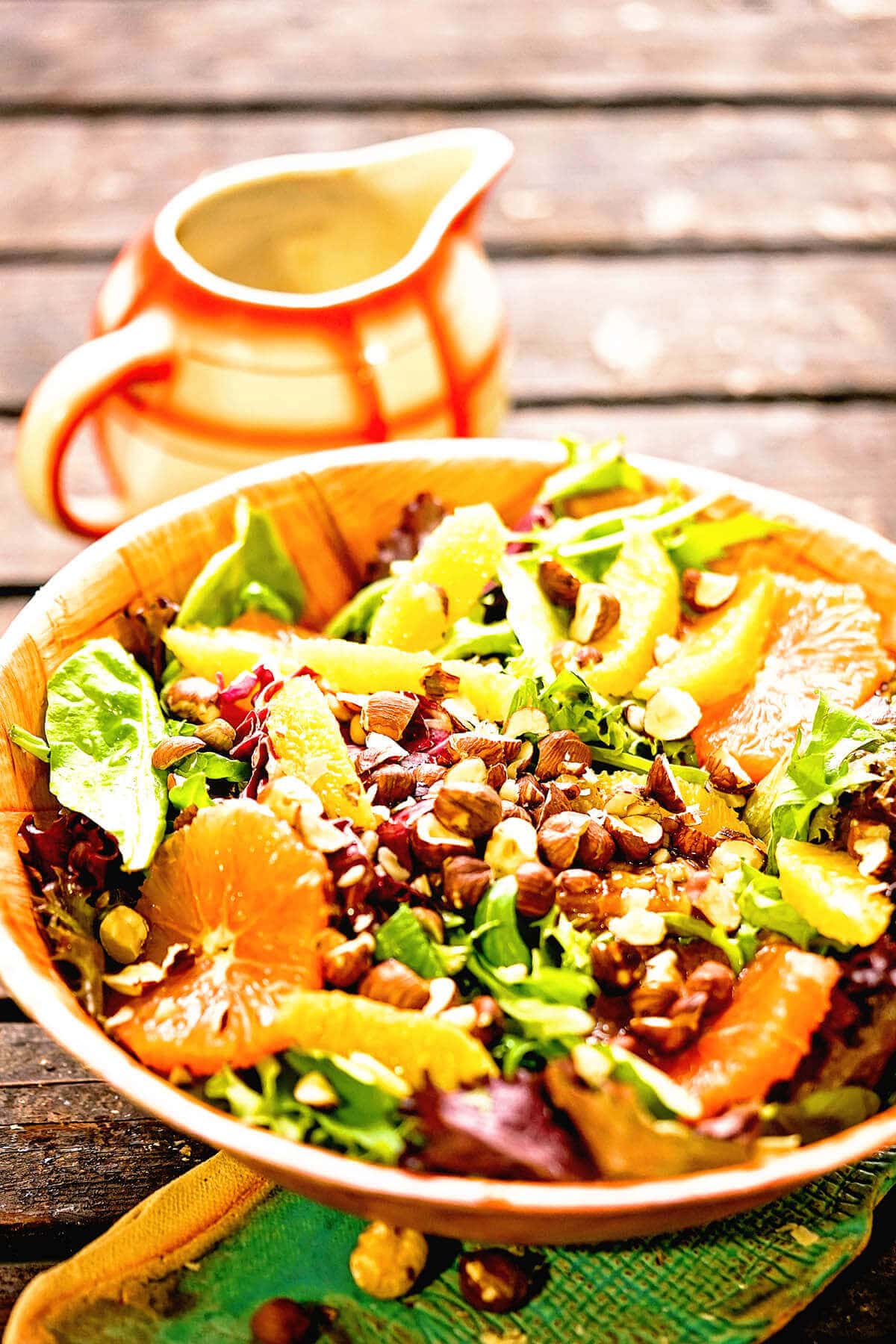 Citrus Salad Recipe in wooden bowl with salad dressing on the side.