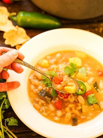 Bowl filled with White Bean Turkey Chili Recipe with spoon.