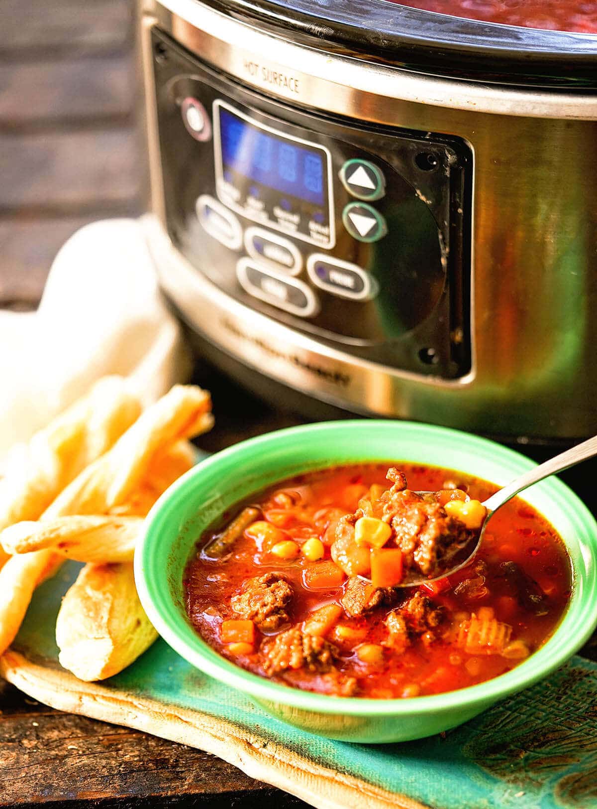 Italian Beef Stew in green bowl served with breadsticks.