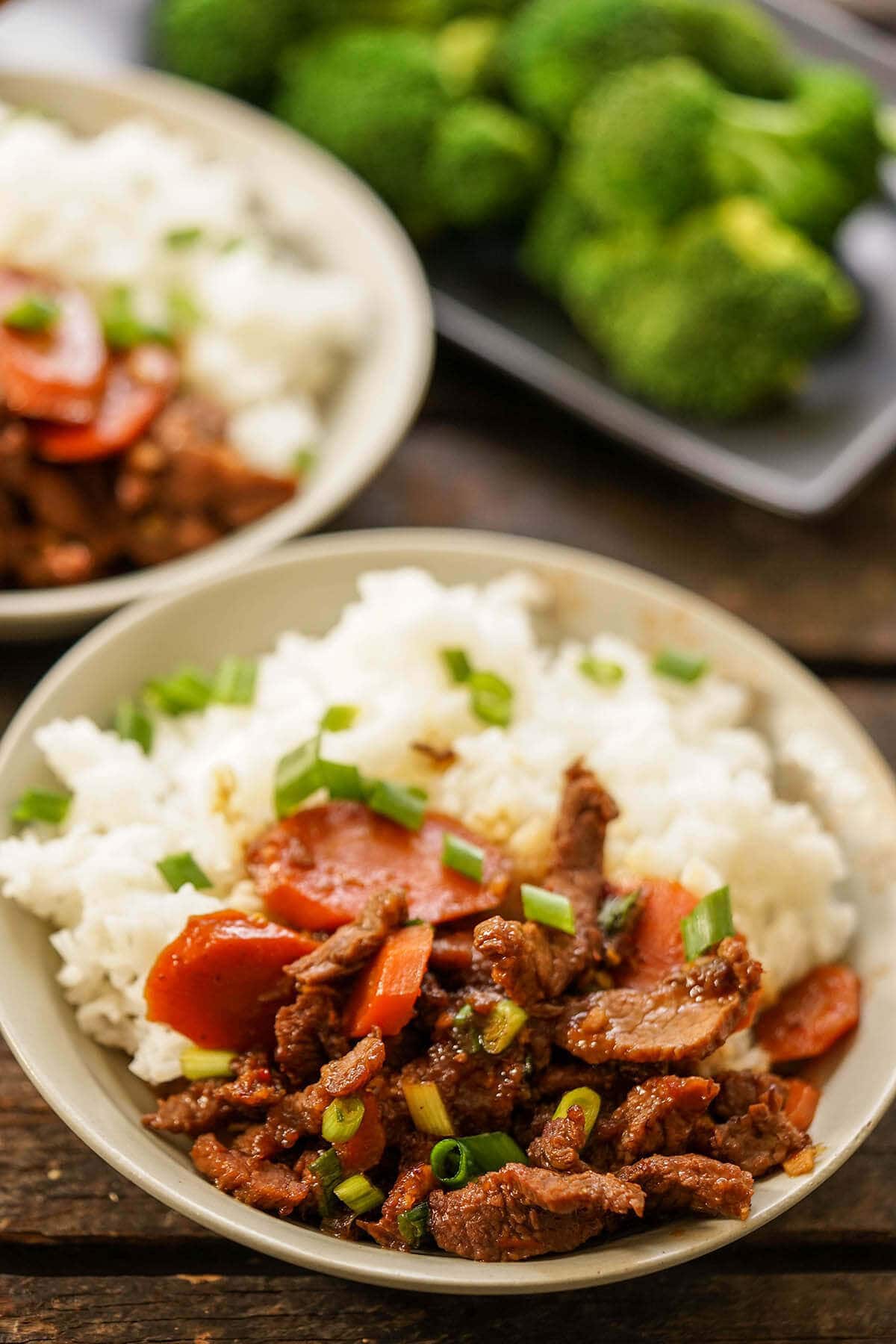 Mongolian Beef in gray bowl served with white rice and broccoli.