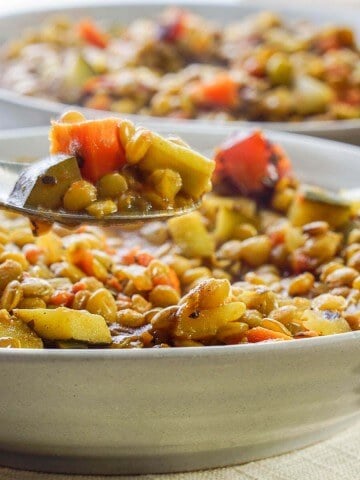 Quick Lentil Soup with Vegetables in gray bowl with spoon.