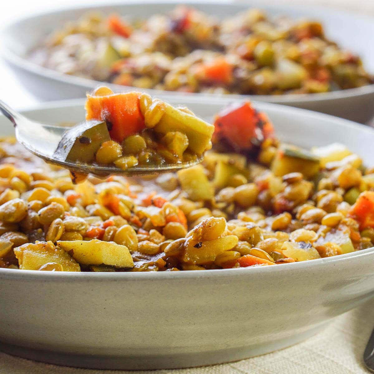 Quick Lentil Soup with Vegetables in gray bowl with spoon.