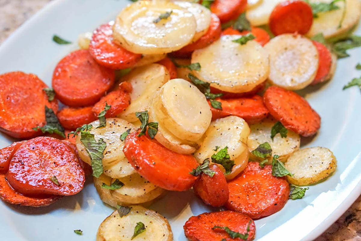 Roasted Carrots on white plate sprinkled with mint.