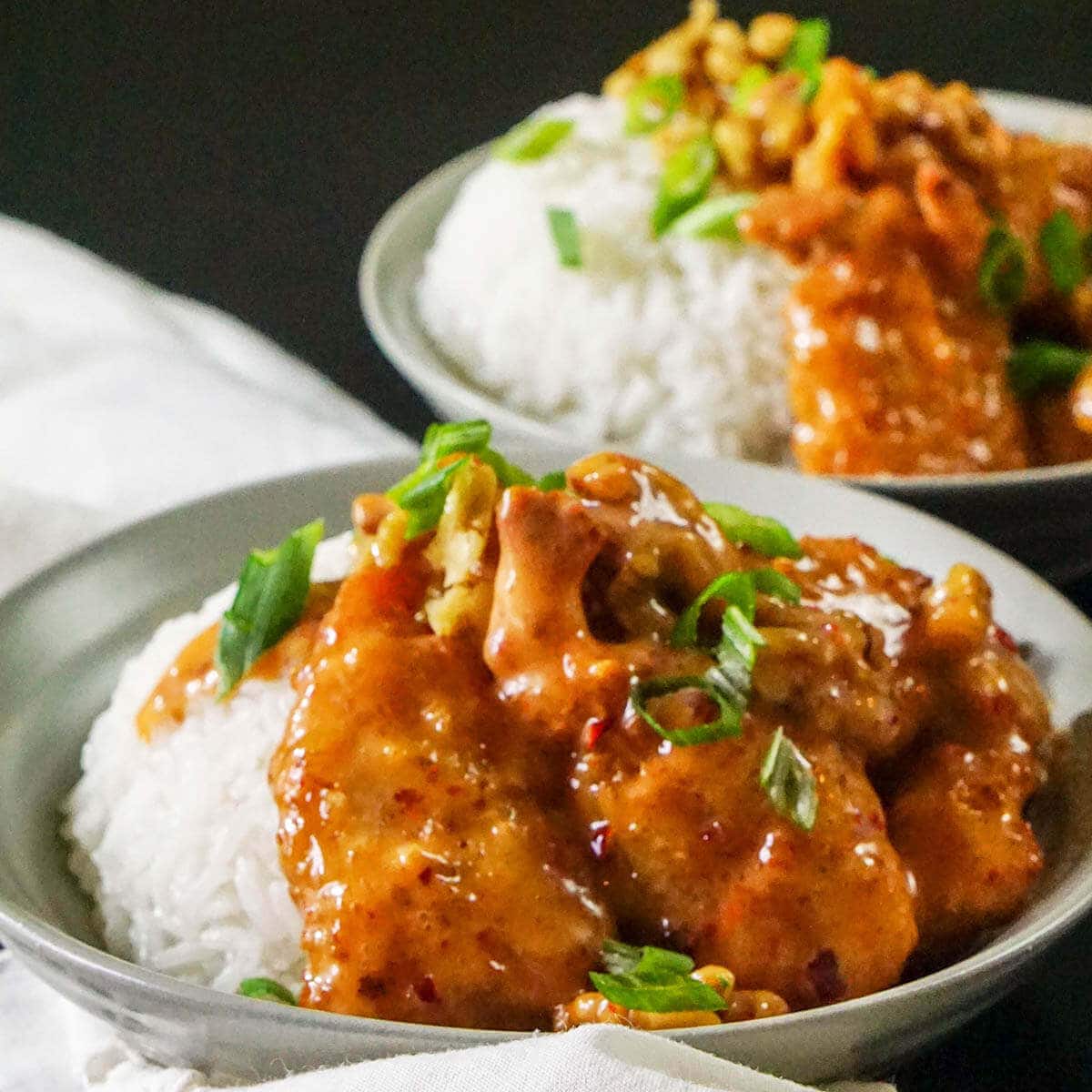 Honey Walnut Shrimp in bowl with white rice topped with diced green onions.