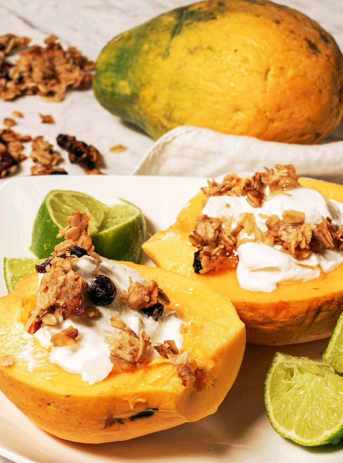 Papaya bowl filled with yogurt, topped with granola.