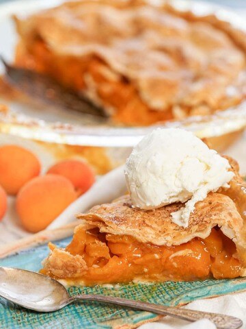 Homemade Apricot Pie Recipe on blue plate with vanilla ice cream .