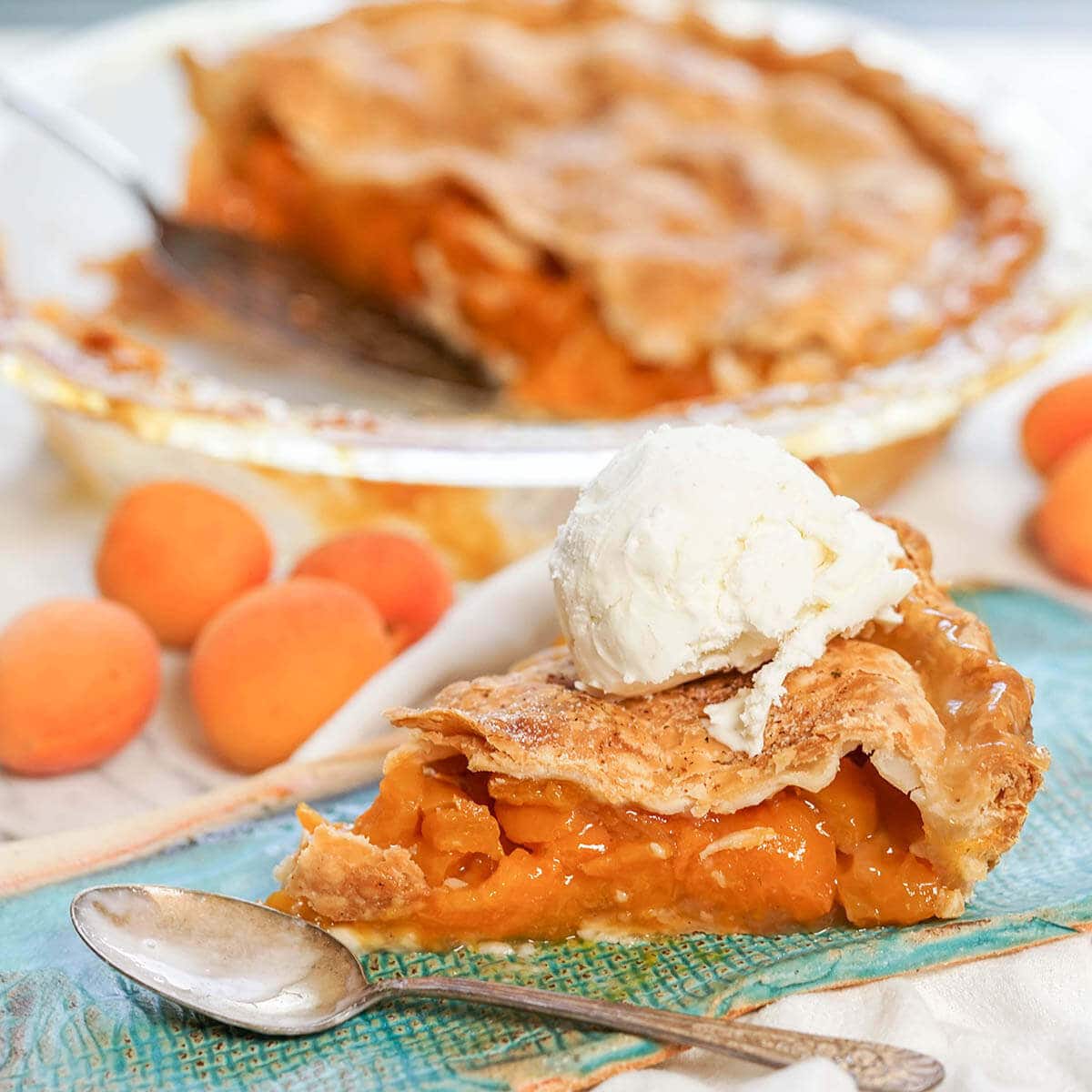 Homemade Apricot Pie Recipe on blue plate with vanilla ice cream .