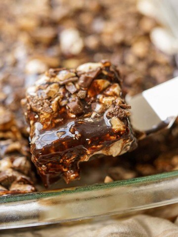 Heath Bar Cake in a glass pan being served with a spatula
