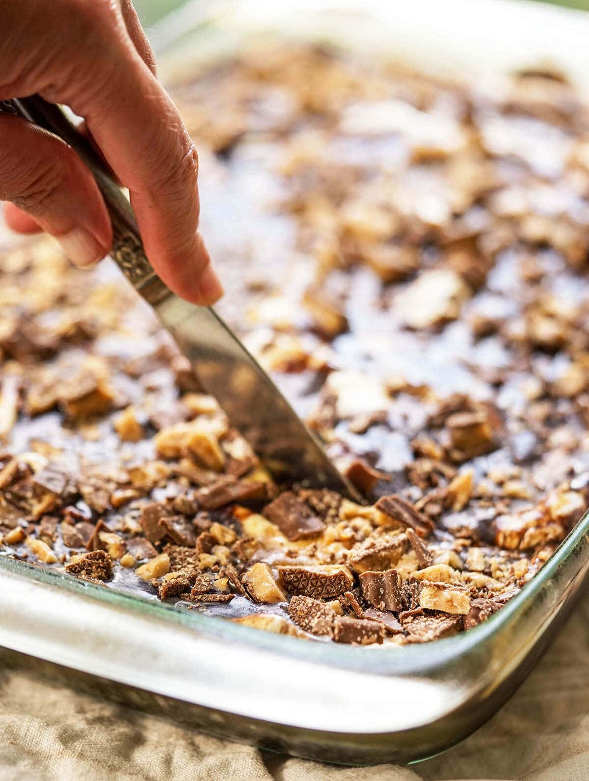 Chocolate Sheet Pan Cake being sliced with knife.