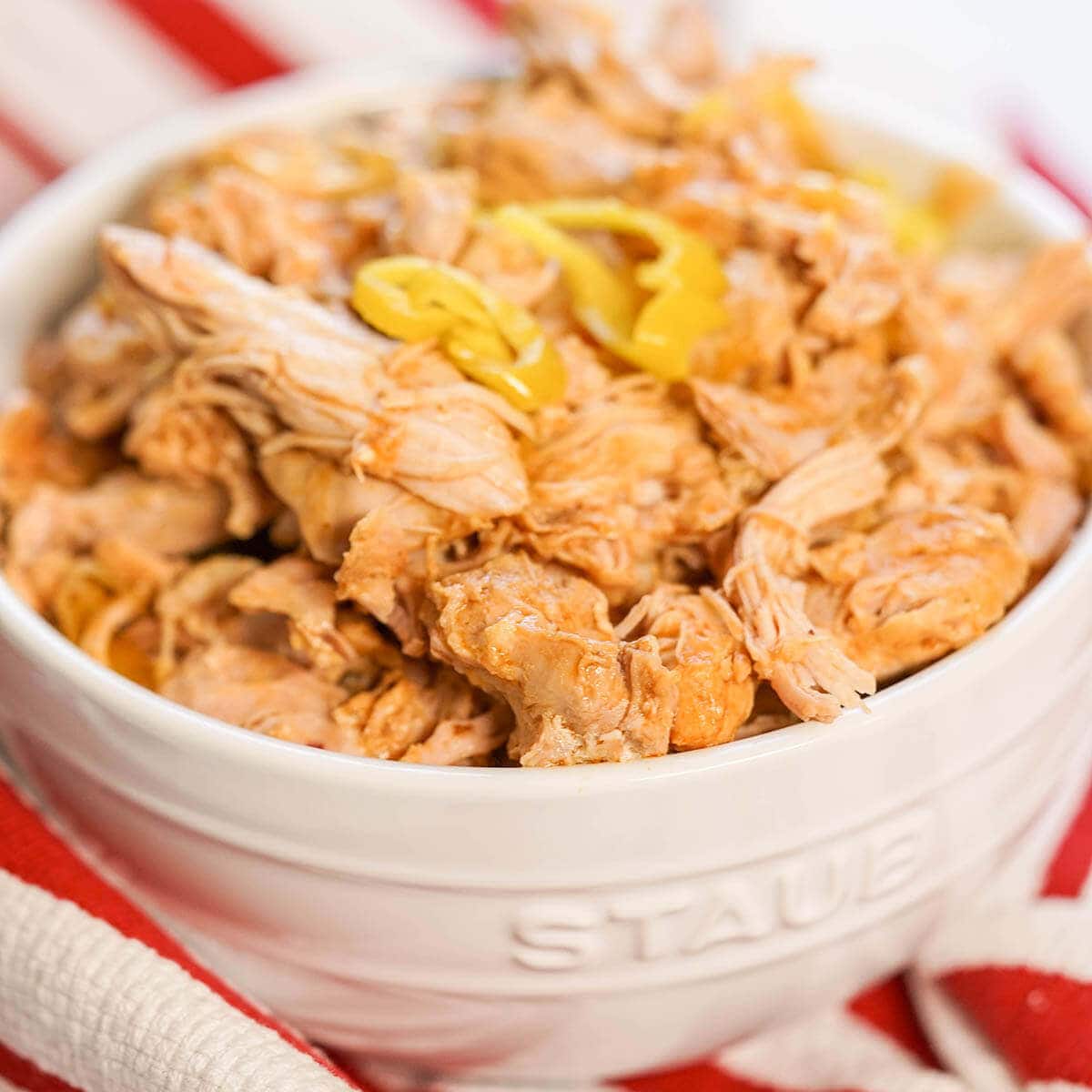 Shredded chicken in white bowl.