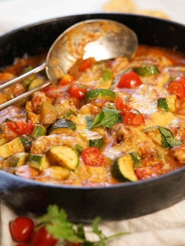 Ground Chicken and Zucchini casserole in cast iron skillet with spoon.