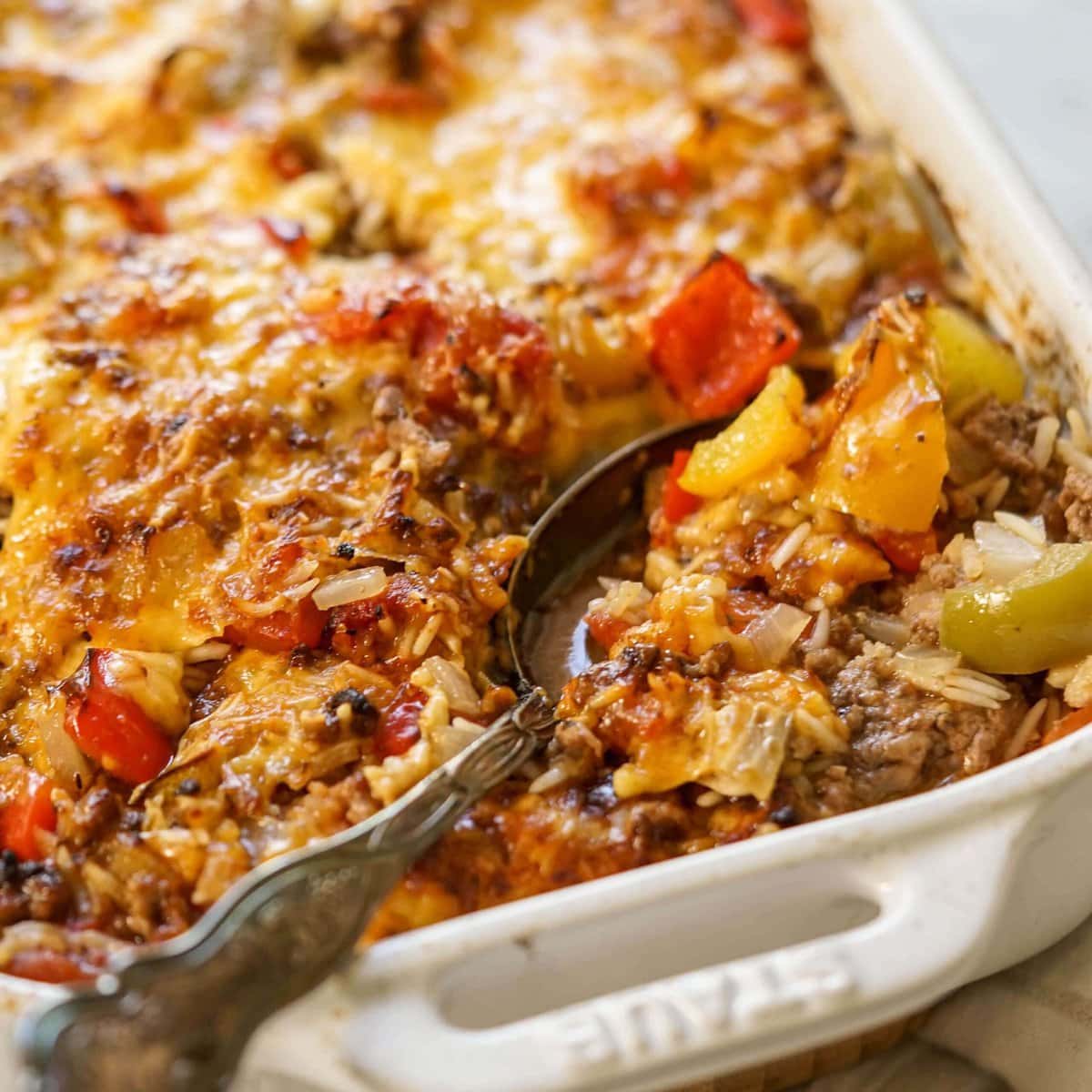 Bell Pepper Hot Dish in white casserole dish with spoon.