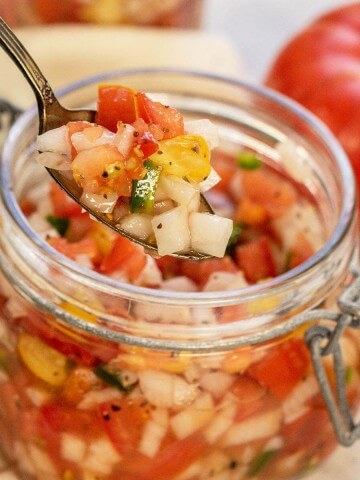 Spoon dishing Tomato Relish out of a jar.