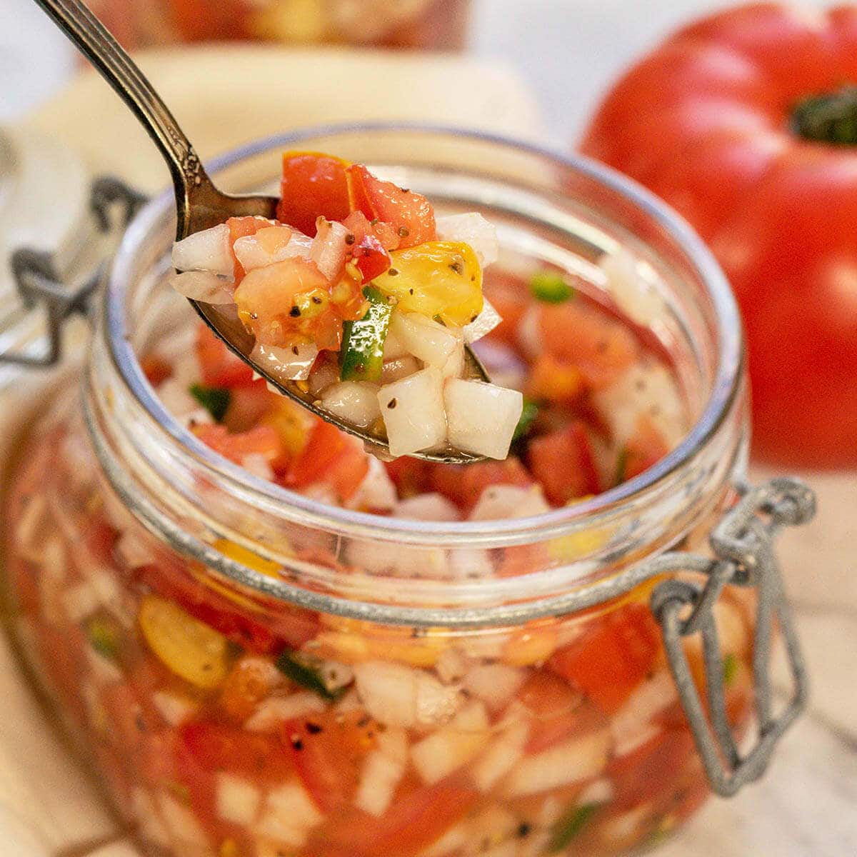 Spoon dishing Tomato Relish out of a jar.