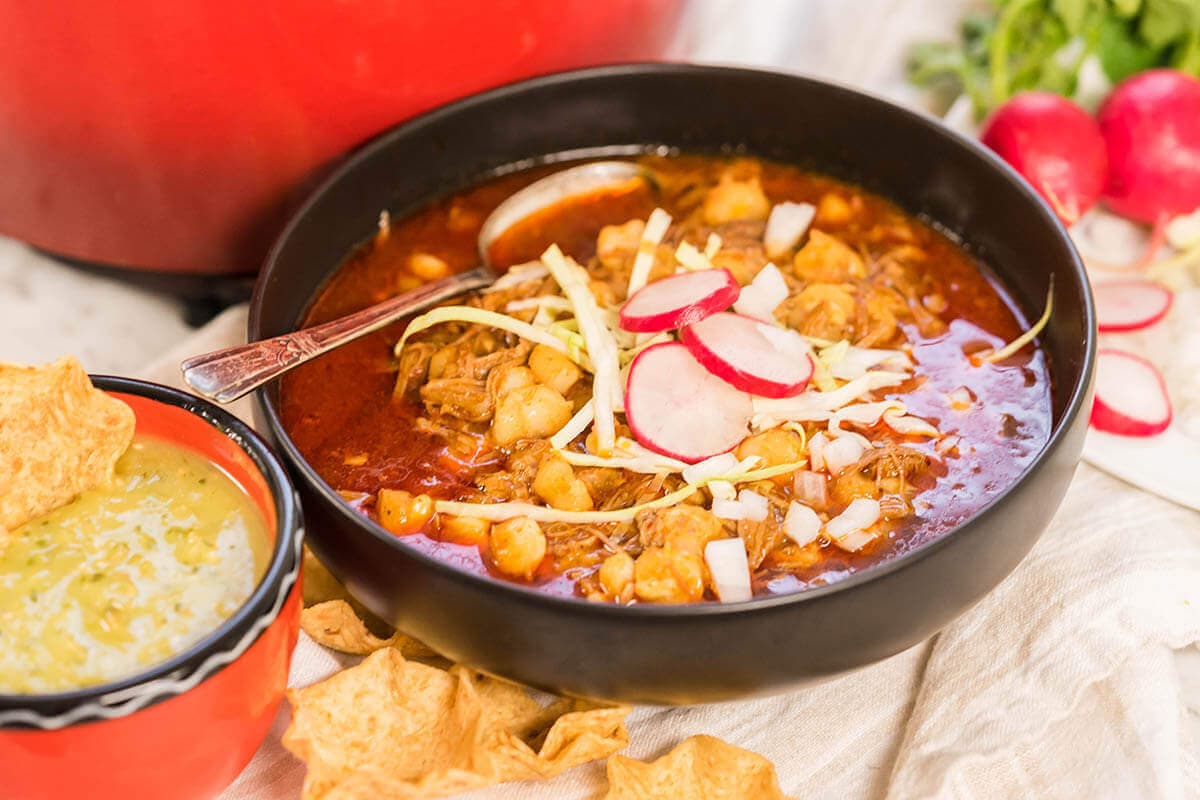 New Mexico style Posole in bowl garnished with radishes, onions and cabbage.