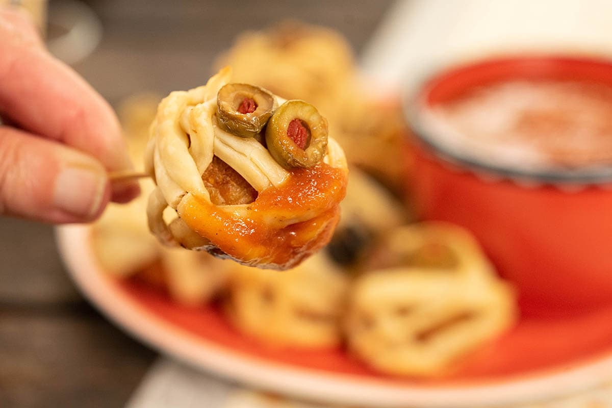 Appetizer on toothpick dipped in marinara sauce.