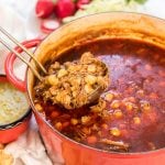 Pozole in Dutch Oven with a ladle of soup being served.