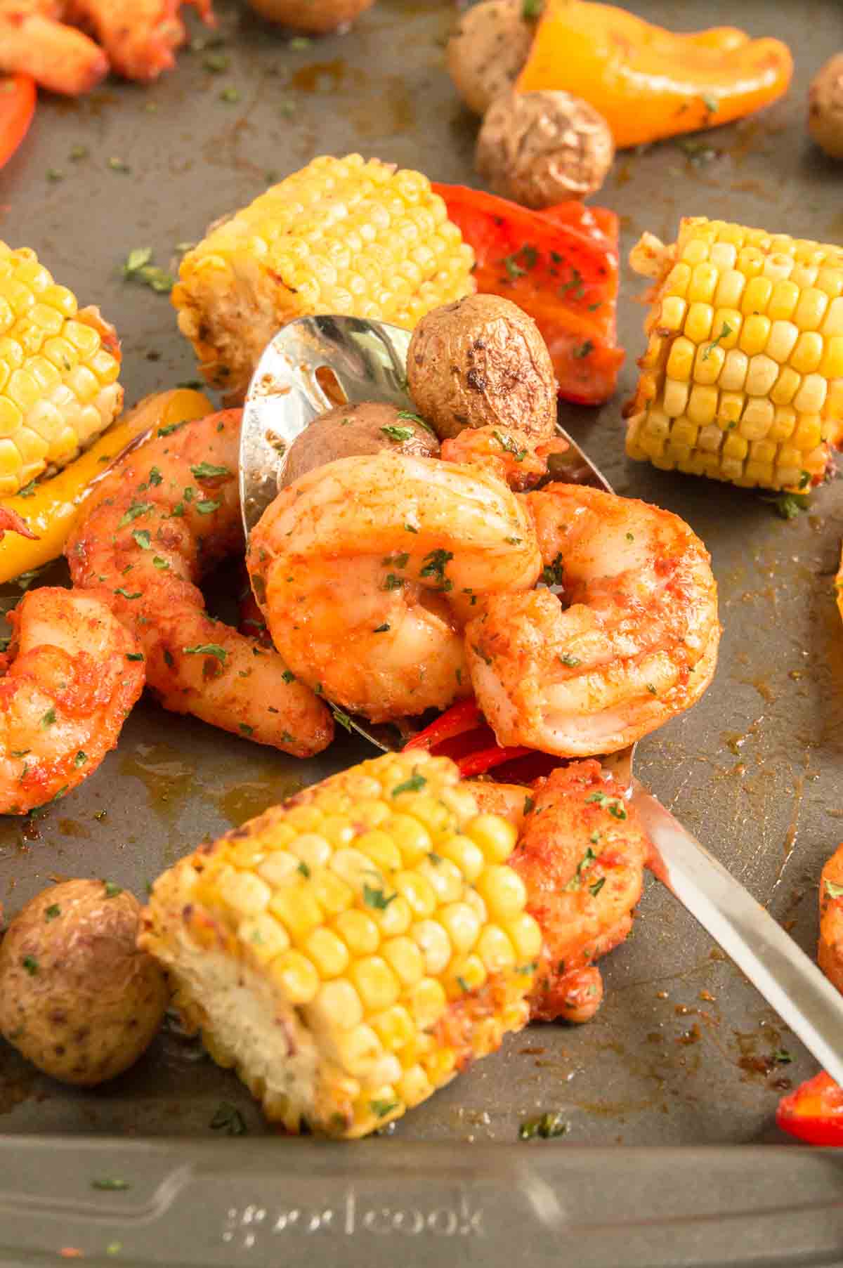 sheet pan filled with roasted corn, potatoes and shrimp 