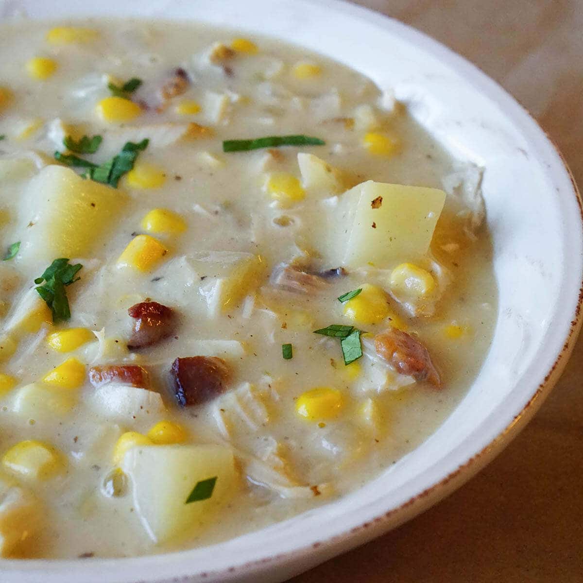 A bowl of turkey corn chowder garnished with chives.