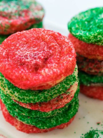 Stacks of sugar cookies rolled in green and red sprinkles.