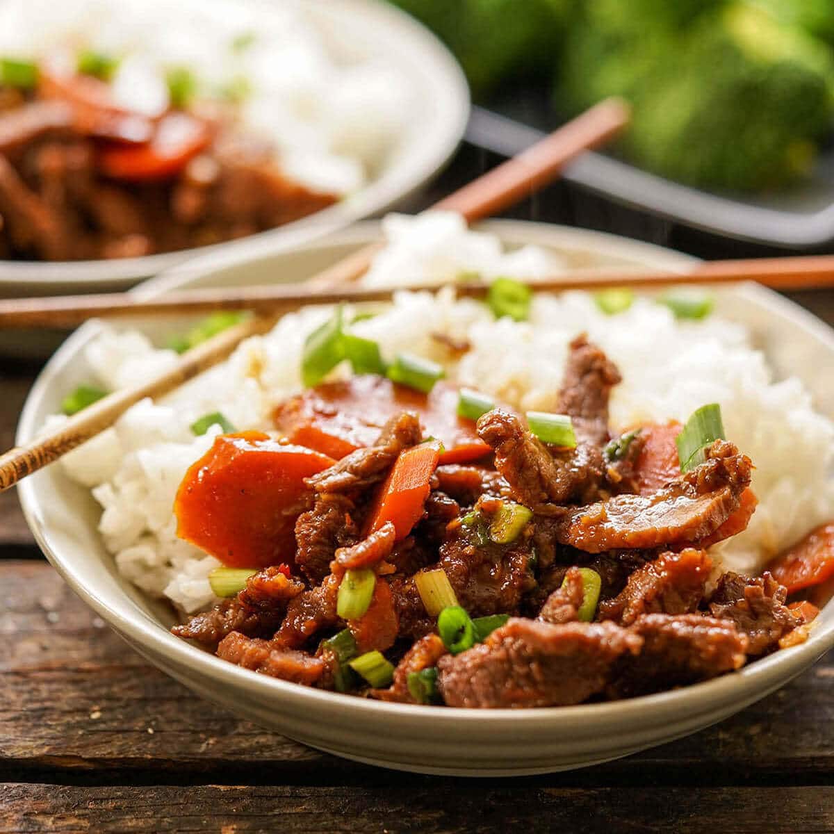 Mongolian Beef served over rice with chopsticks.