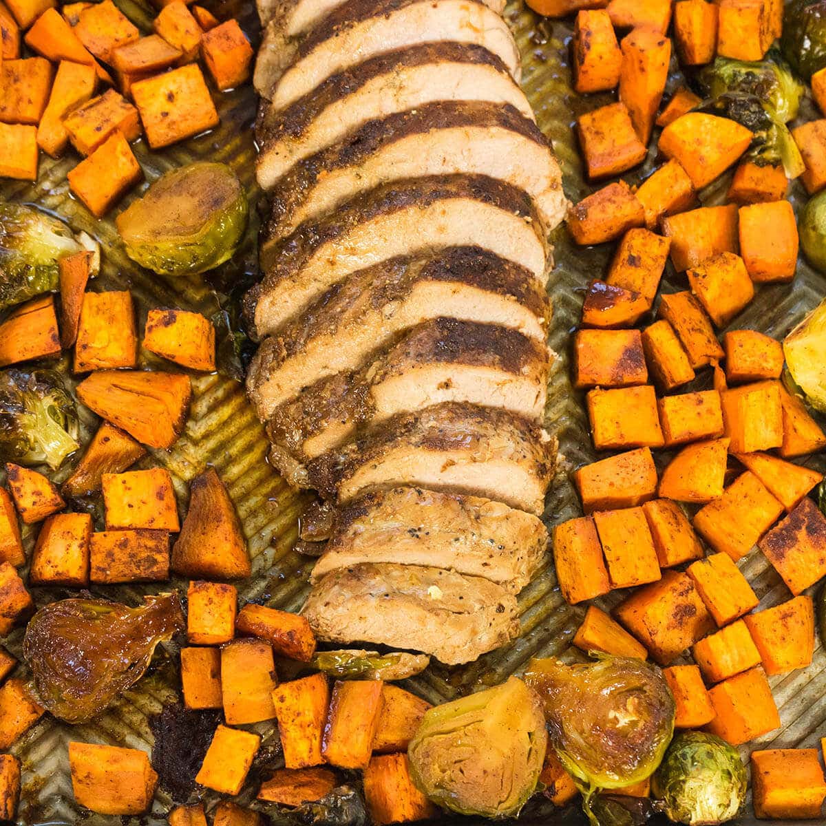 Pork and potatoes on sheet pan with sprouts.