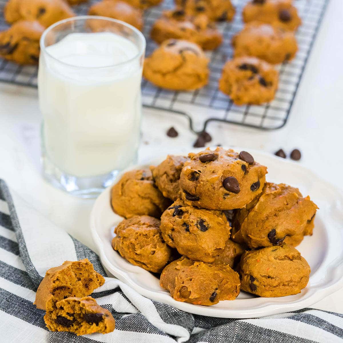 A stack of chewy pumpkin chocolate chip Cookes with glass of milk