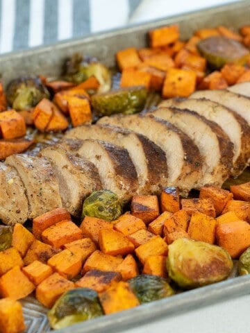 Roasted pork tenderloin with sweet potatoes on sheet pan.