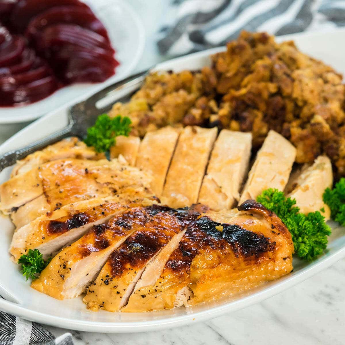 A platter filled with Crockpot Stuffed Turkey Breast.