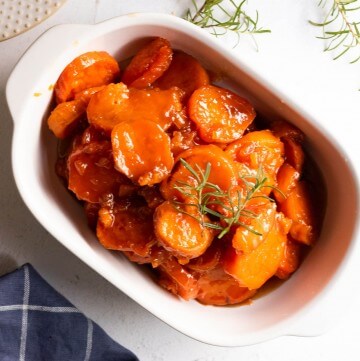 Cooked yams with a sweet glaze in white bowl, ready to serve.